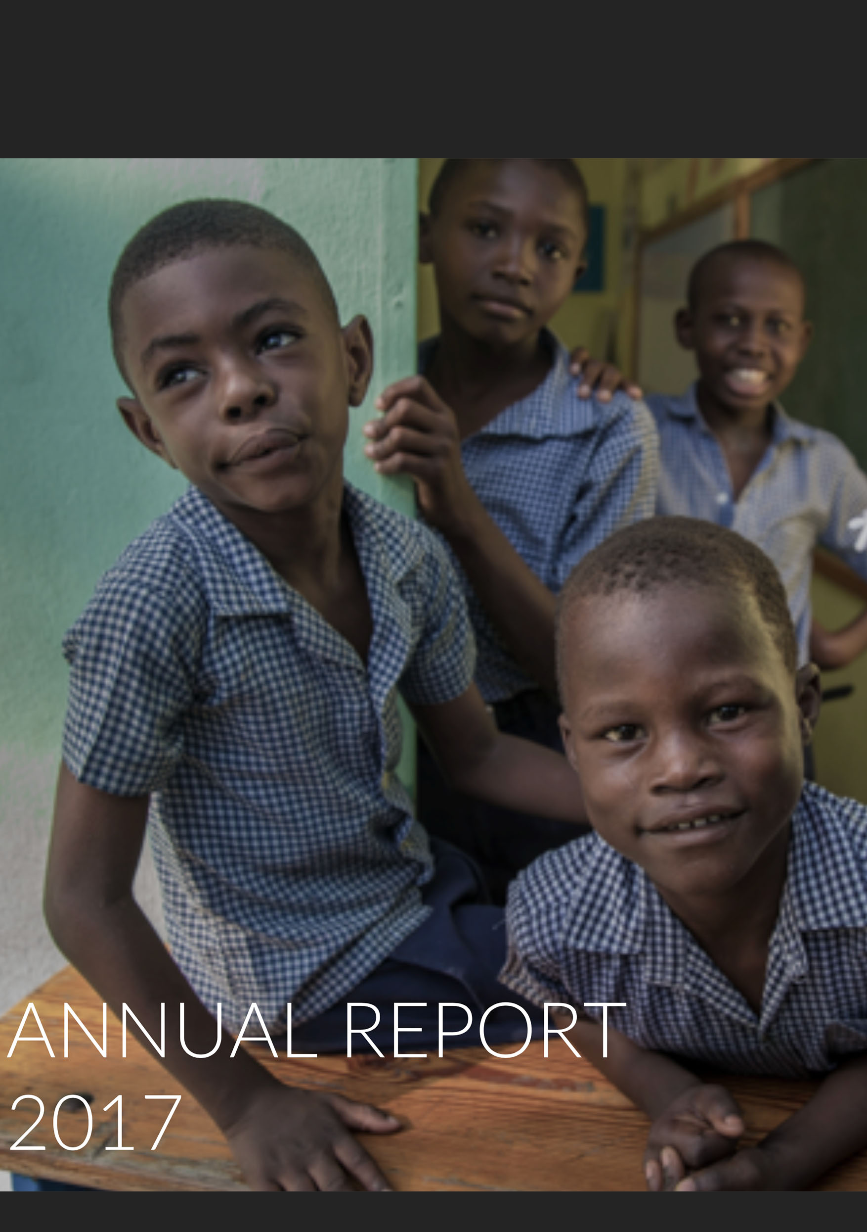 A cover photo from the organizations 2017 annual Impact Report. The image shows four Haitian students posing for a photo.