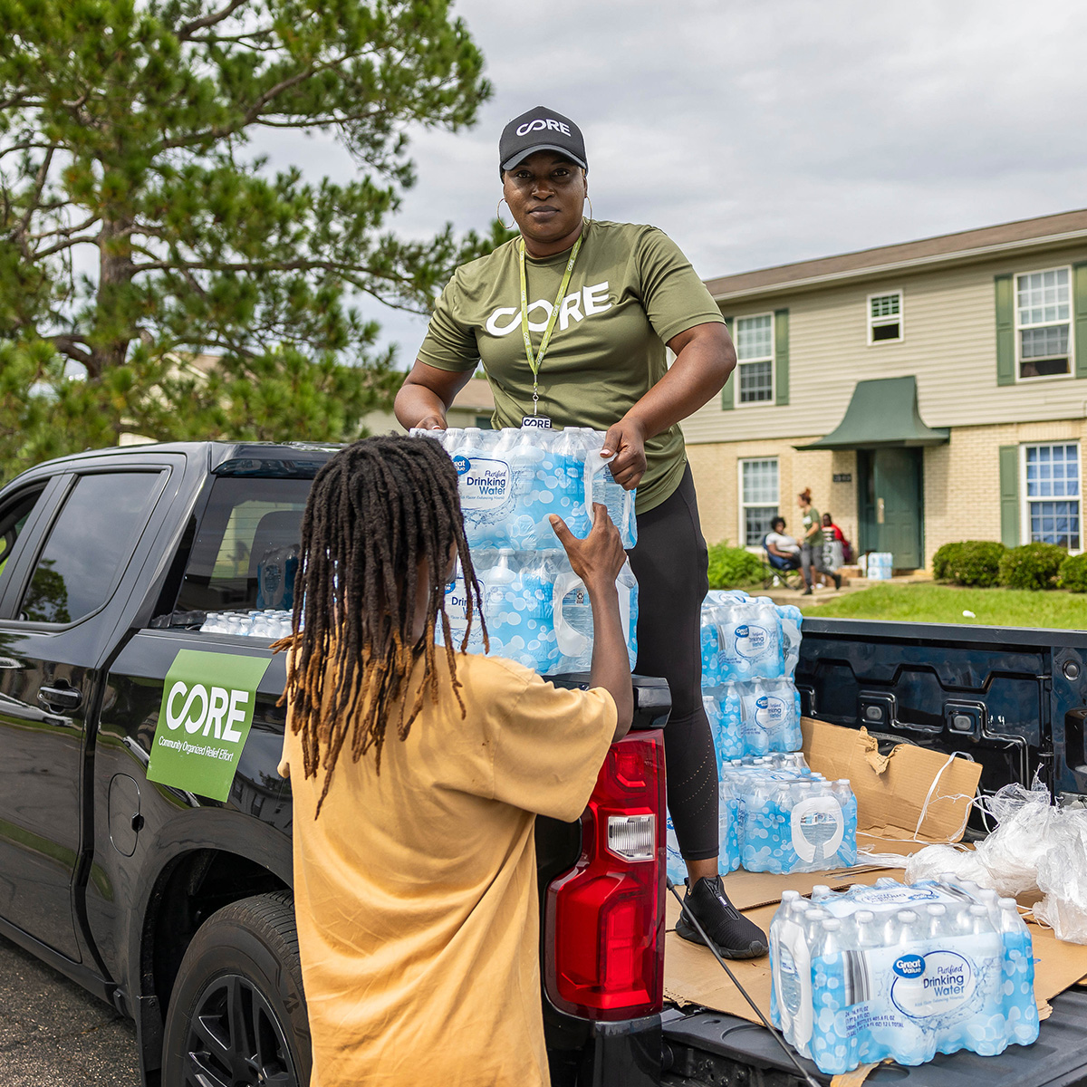 CORE team member in the back of a truck distributing cases of water in Georgia after Hurricane Idalia.