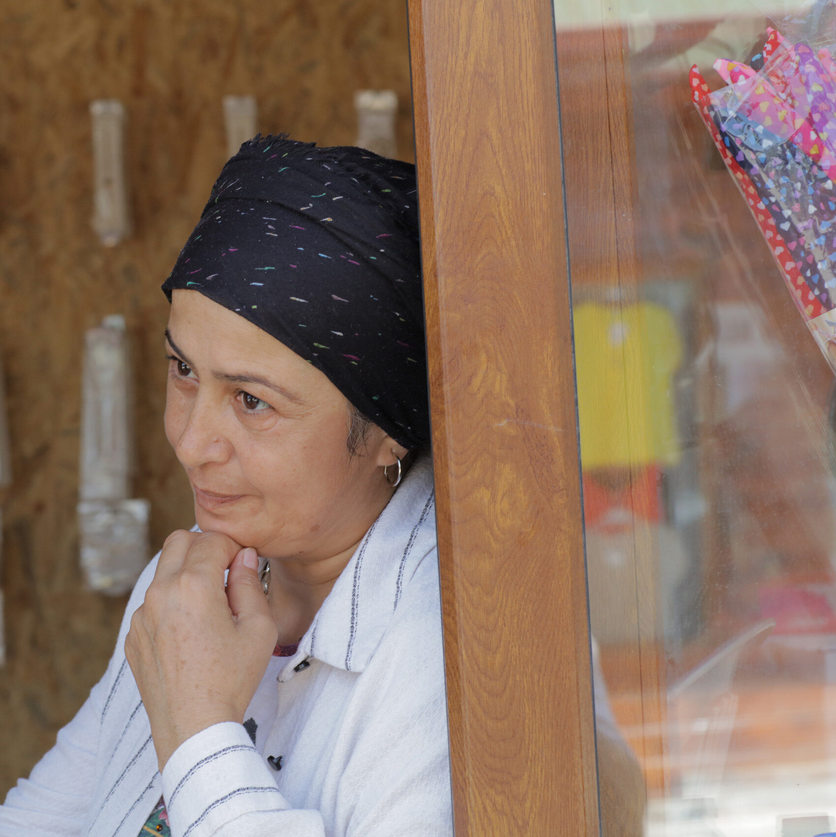 Turkish woman leaning in one of her house's pillar.