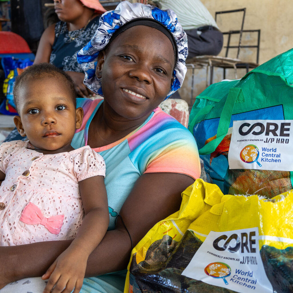 A Haitian woman with her son surrounded by CORE bags with food and health kits.
