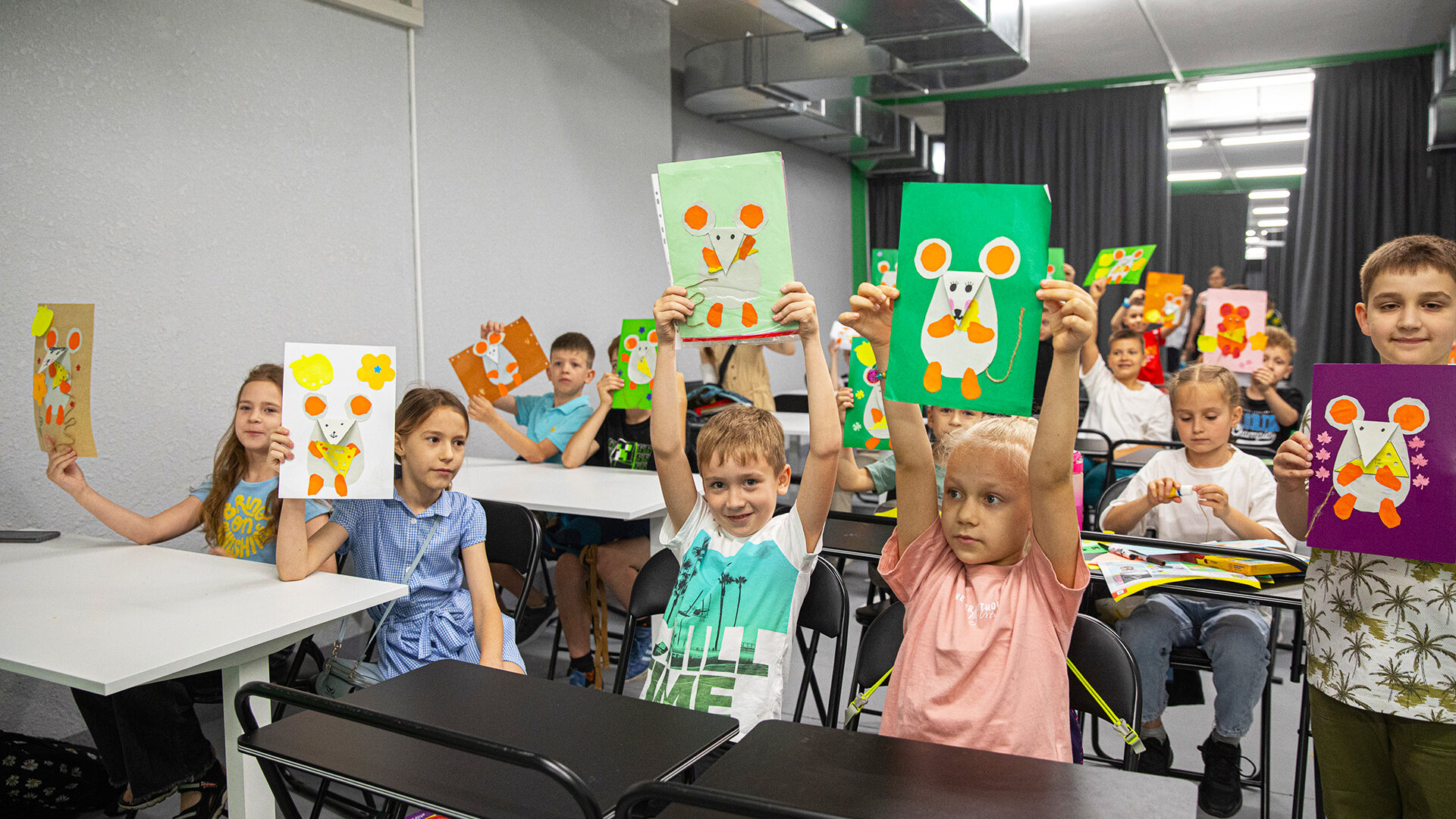 Ukraine - hero 2_kids holding up artwork in classroom in Mykolaiv