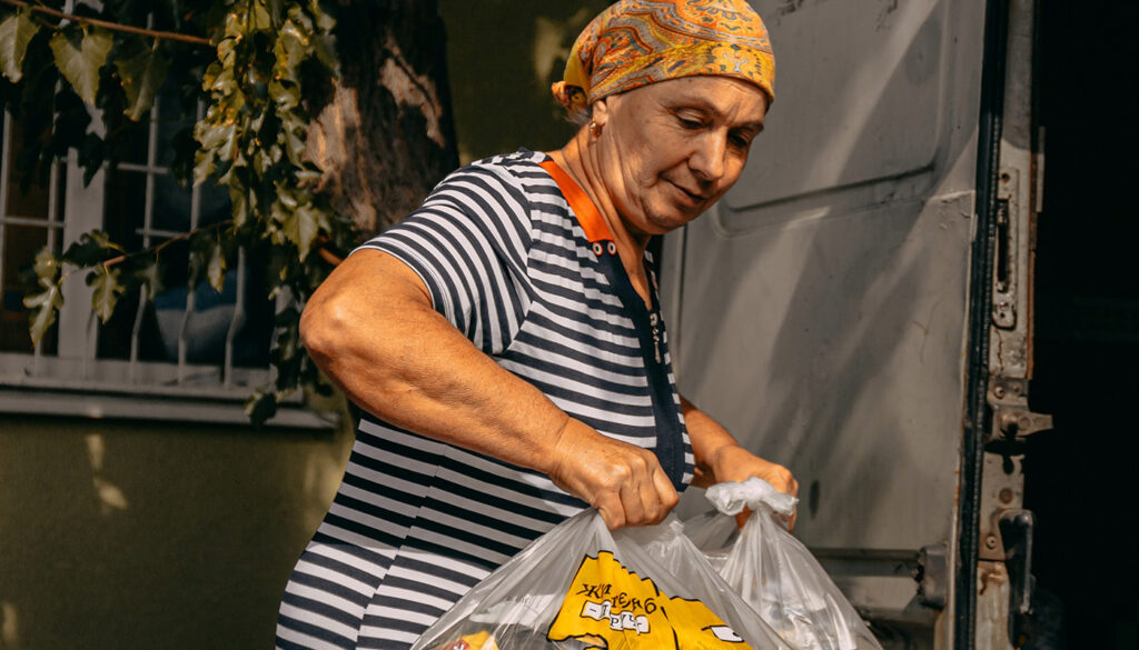 An Ukrainian woman receiving a food package from CORE.