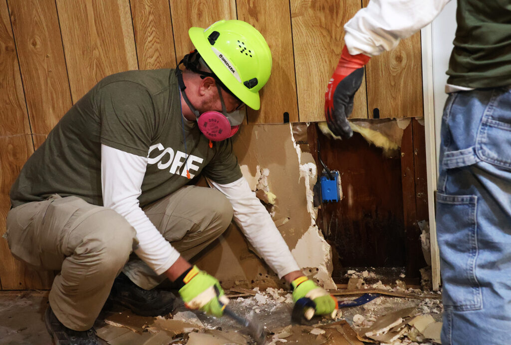 A CORE team member does muck and gut work, tearing out water damage in a home that was effected by the historic flooding in San Diego in January 2024.