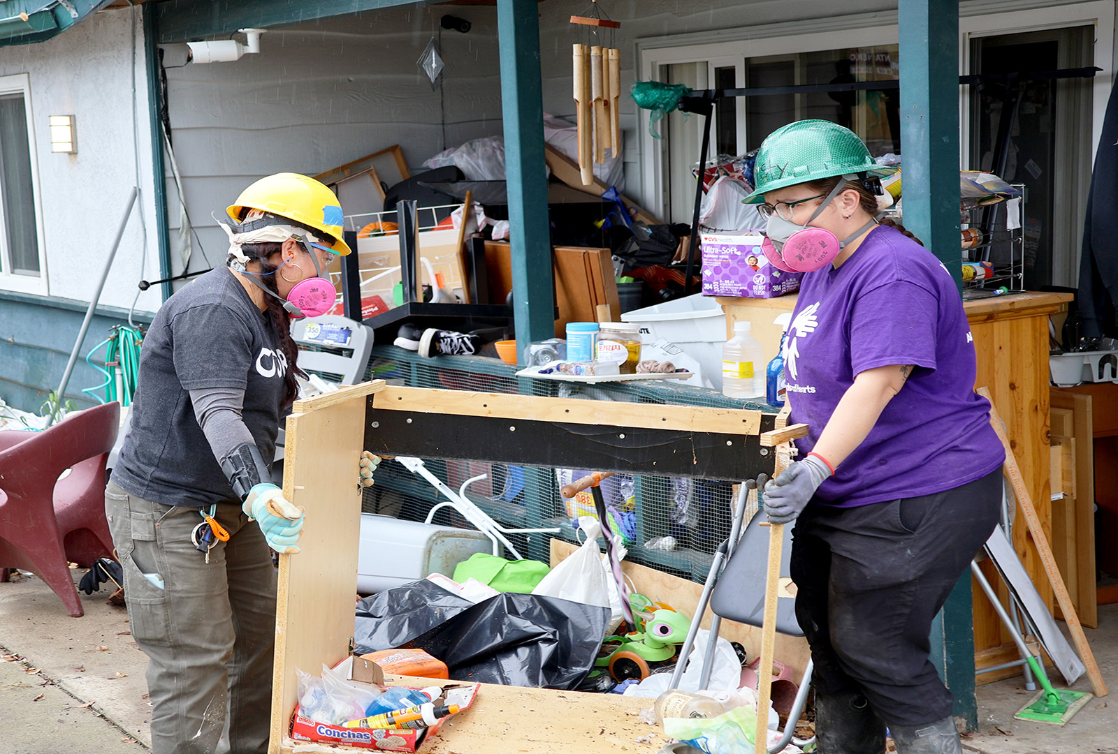 Team members from CORE and All Hands And Hearts carry out a piece of cabinet from a home that was damaged in the historic flooding in San Diego in January 2024.