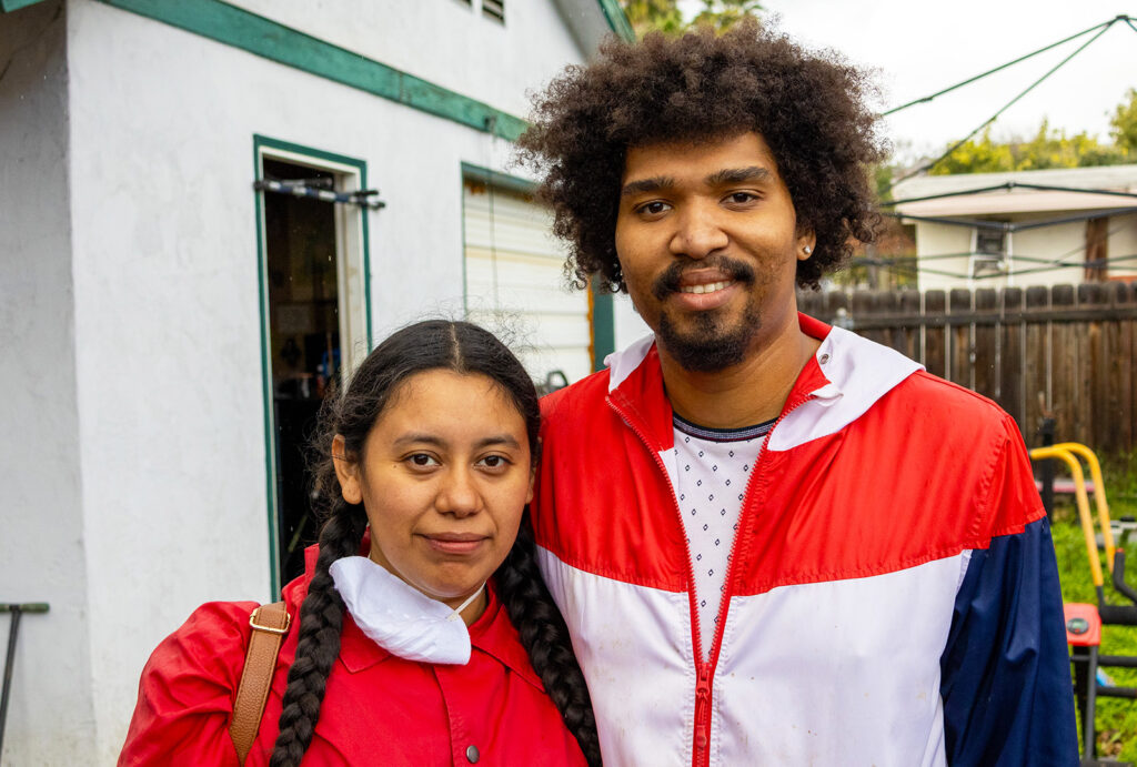 Roxanne and Jonathan pose for a photo in their backyard, a few weeks after historic flooding in San Diego damaged their home.