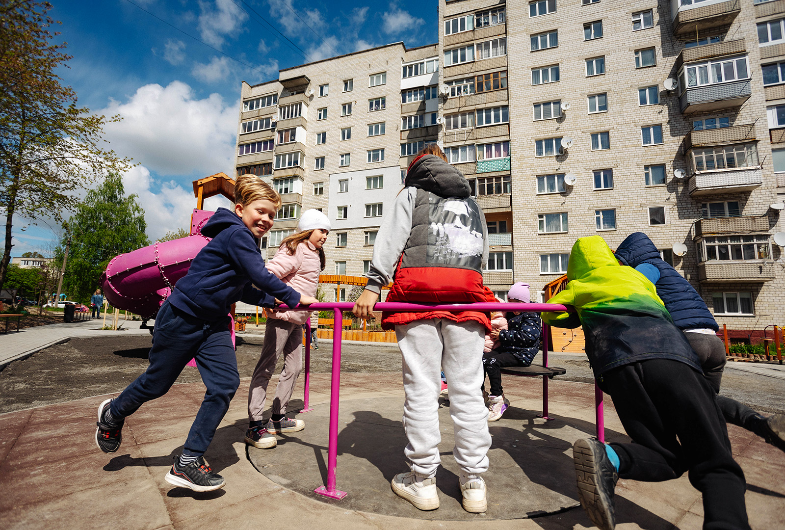 Six children playing on a roundabout.