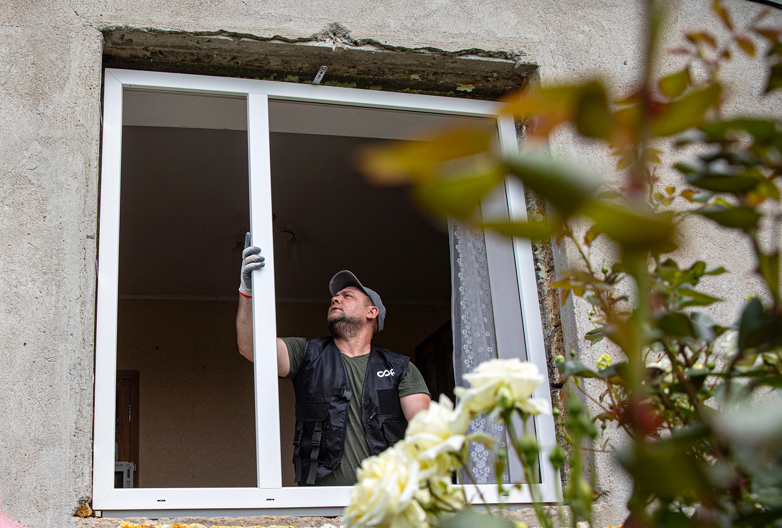 A man replacing a window that had been damaged during the war.