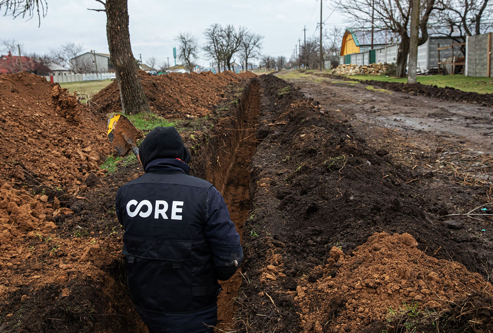 Construction worker works inside dug up ground for water pipe construction in Zelenyi Hai.