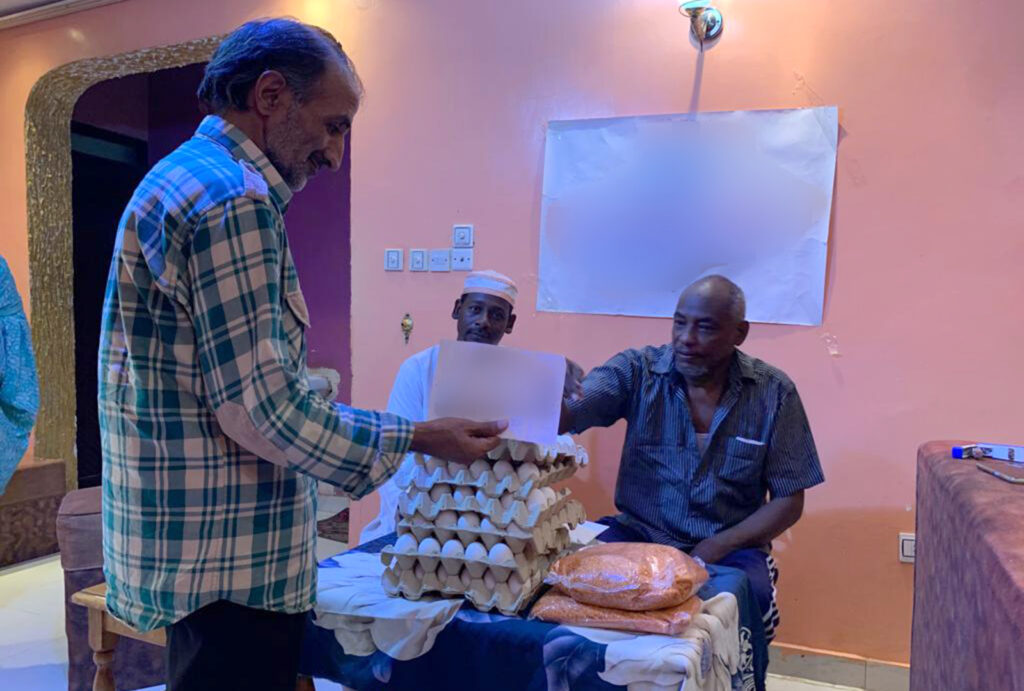 A member of NIDAA's staff supplies a woman with a nutritional voucher at a Women's Response Room in Khartoum.