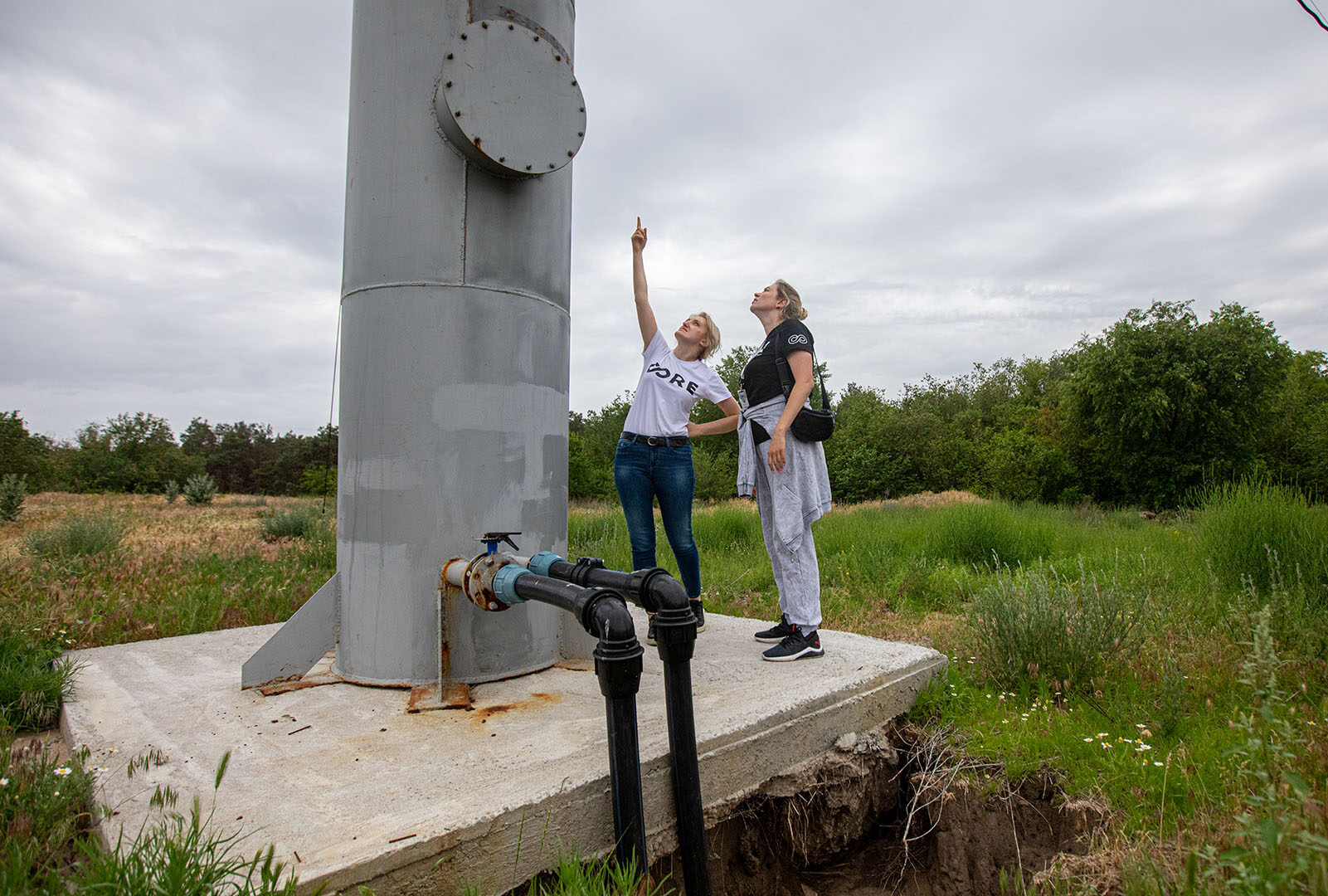 CORE staff looking up at a water tower in Lymany, Mykolaiv.