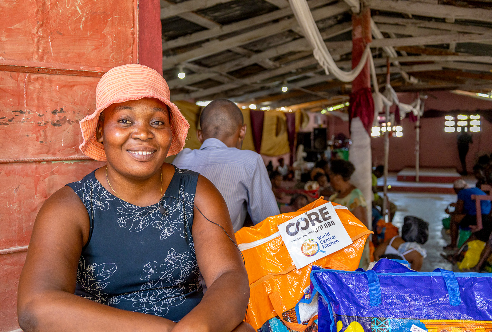 A beneficiary takes a portrait photo after receiving her food kit.