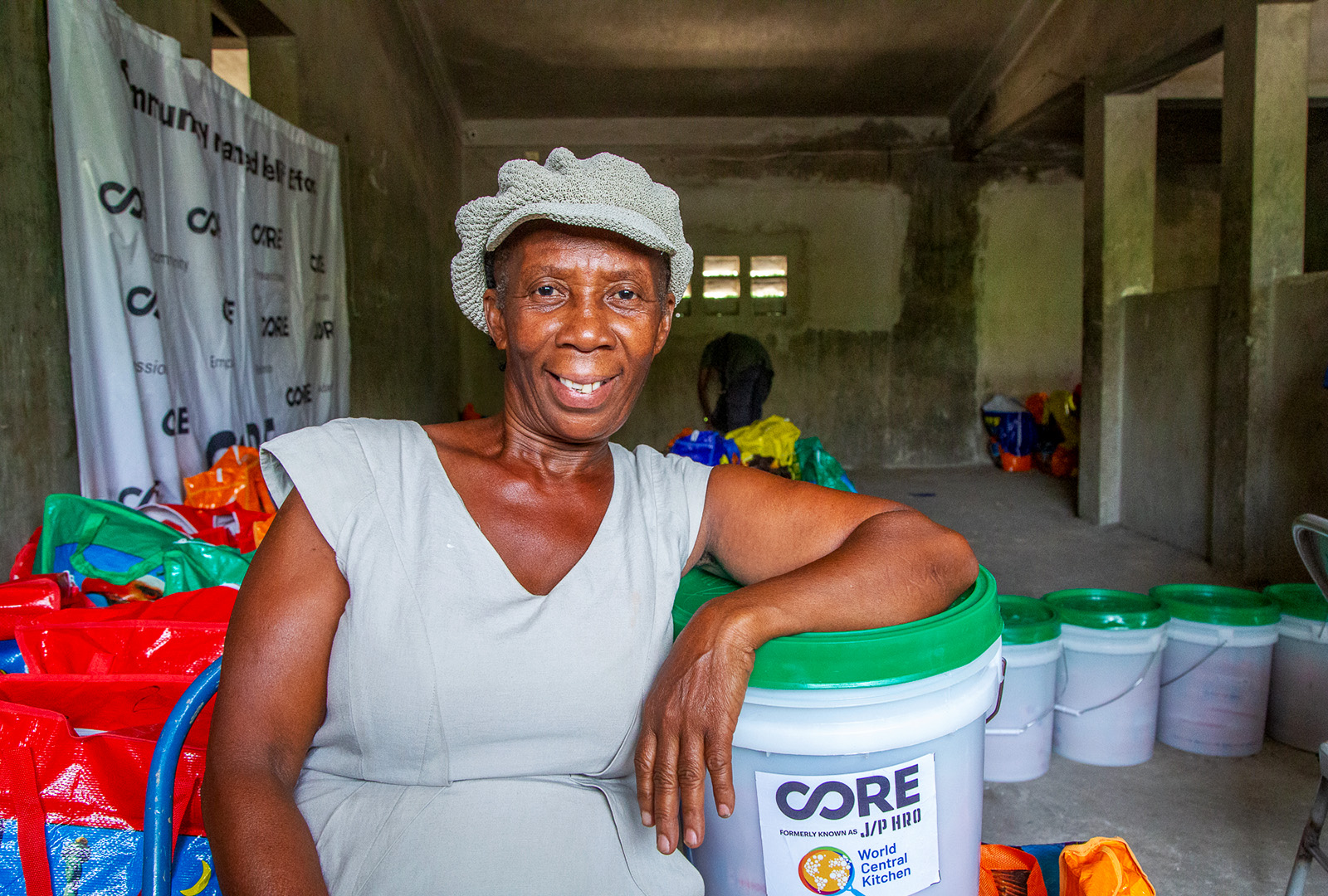 A woman take a photo with her food kit that CORE and World Central Kitchen provided to address the food crisis in Haiti.