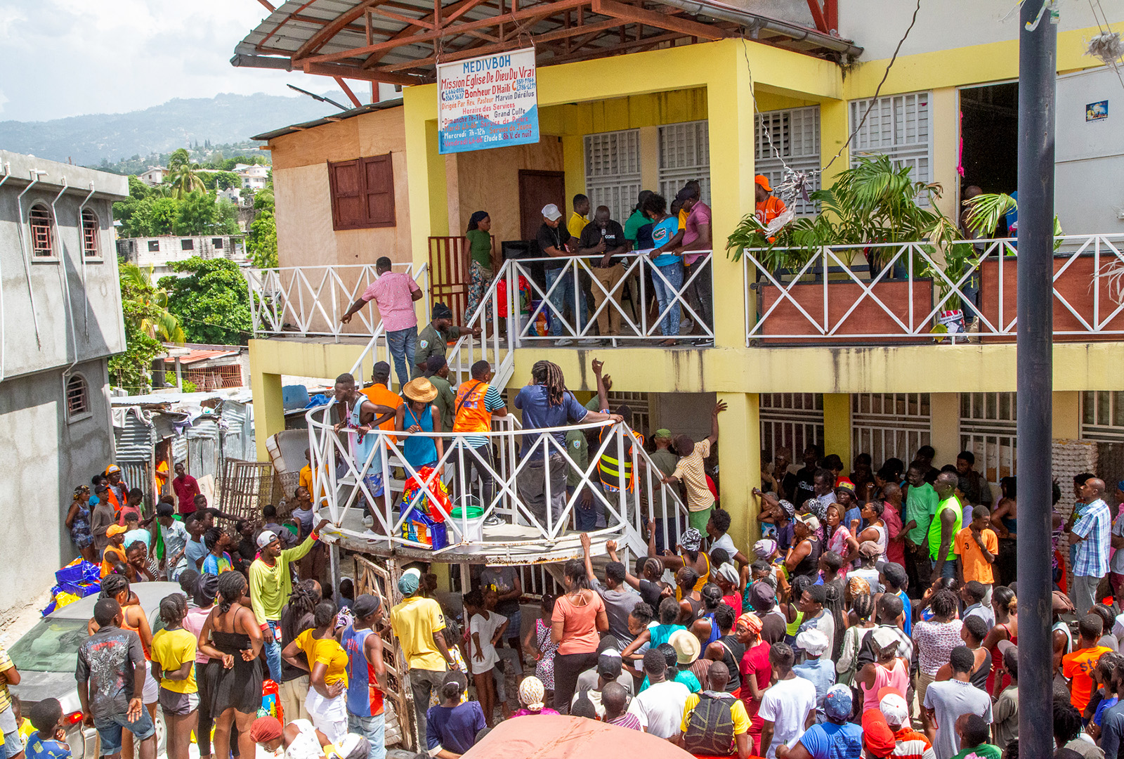 A line of people outside of a building waiting to receive their food kits amidst the food crisis in Haiti.