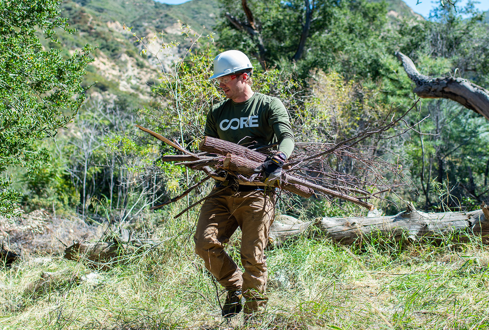 CORE team member clearing out overgrown branches in Big Tujunga Canyon, to help prevent wildfires.