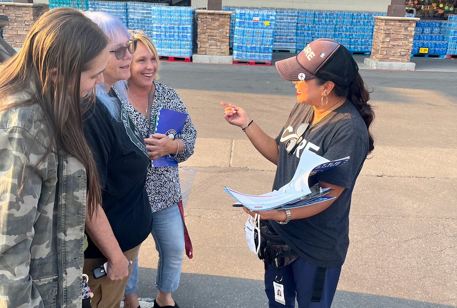 A member of CORE's team talks with Big Bear Lake residents outside of a grocery store.