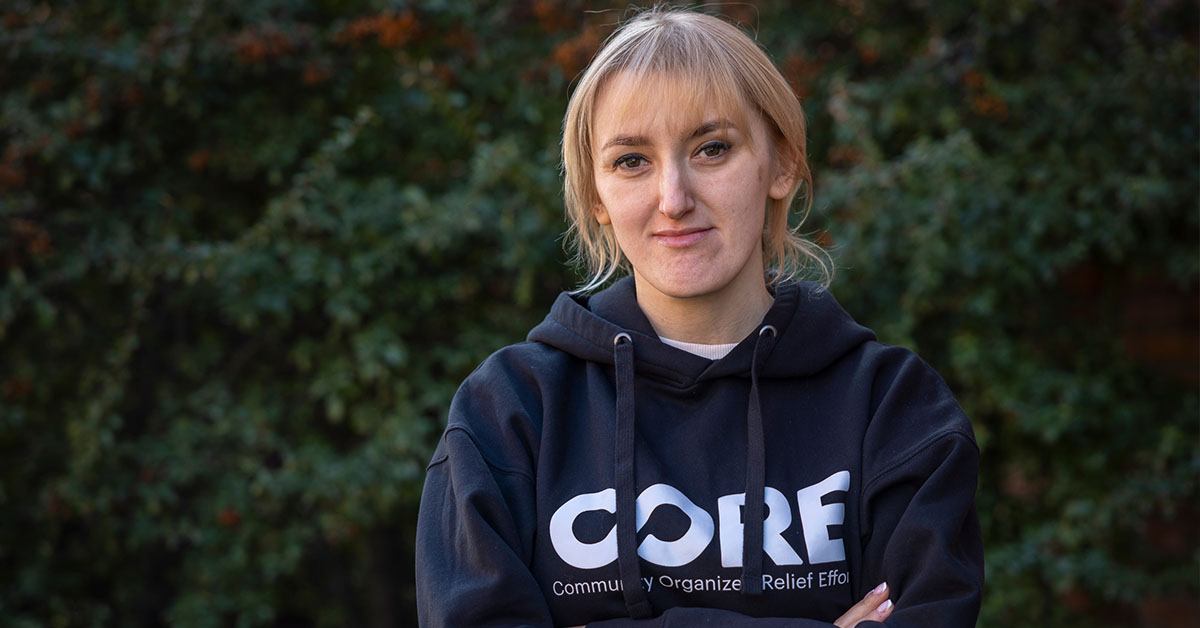 CORE leadership - Liana from Ukraine stands with her arms crossed in a CORE sweatshirt