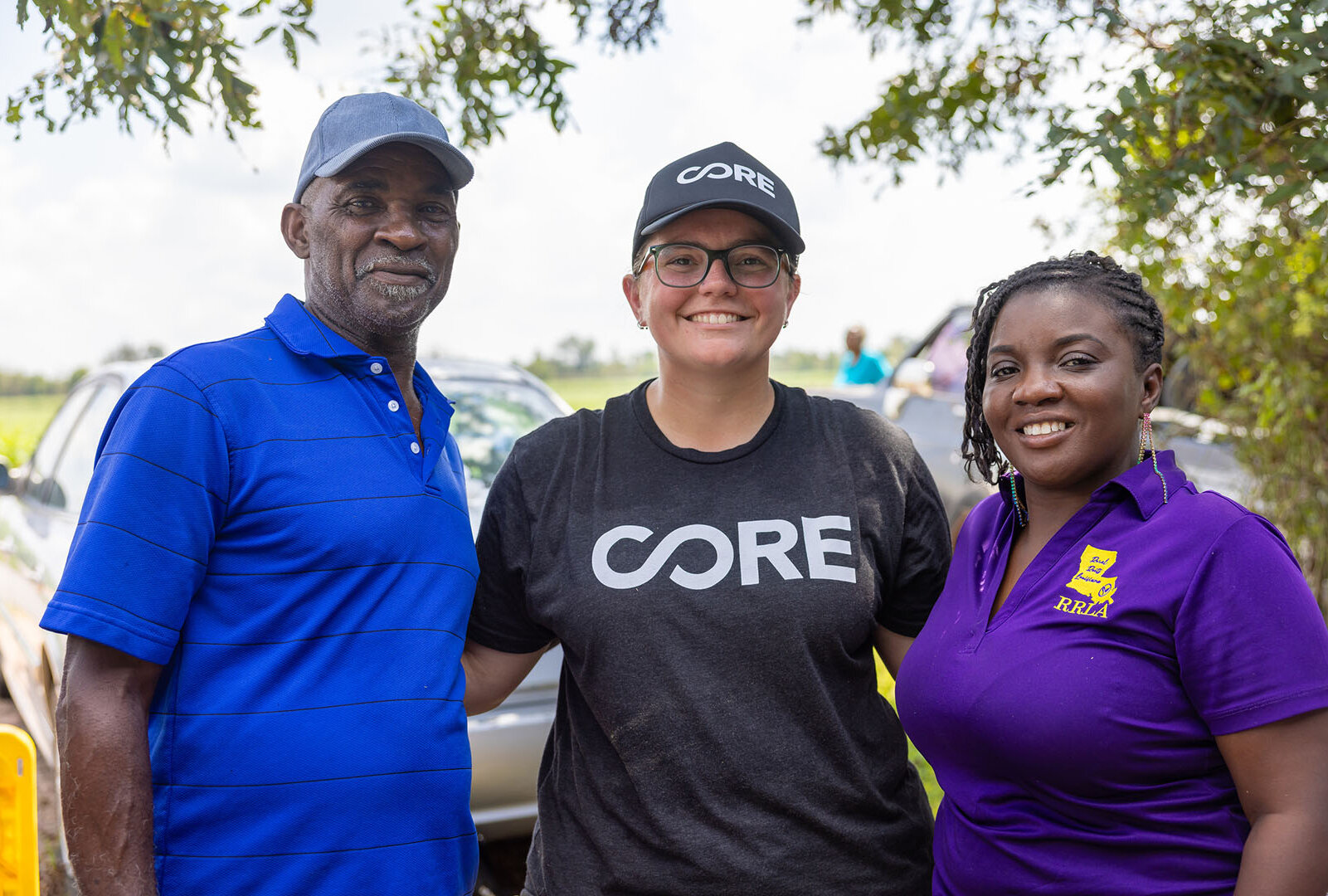 CORE volunteer poses with partner from Rural Roots and a beneficiary