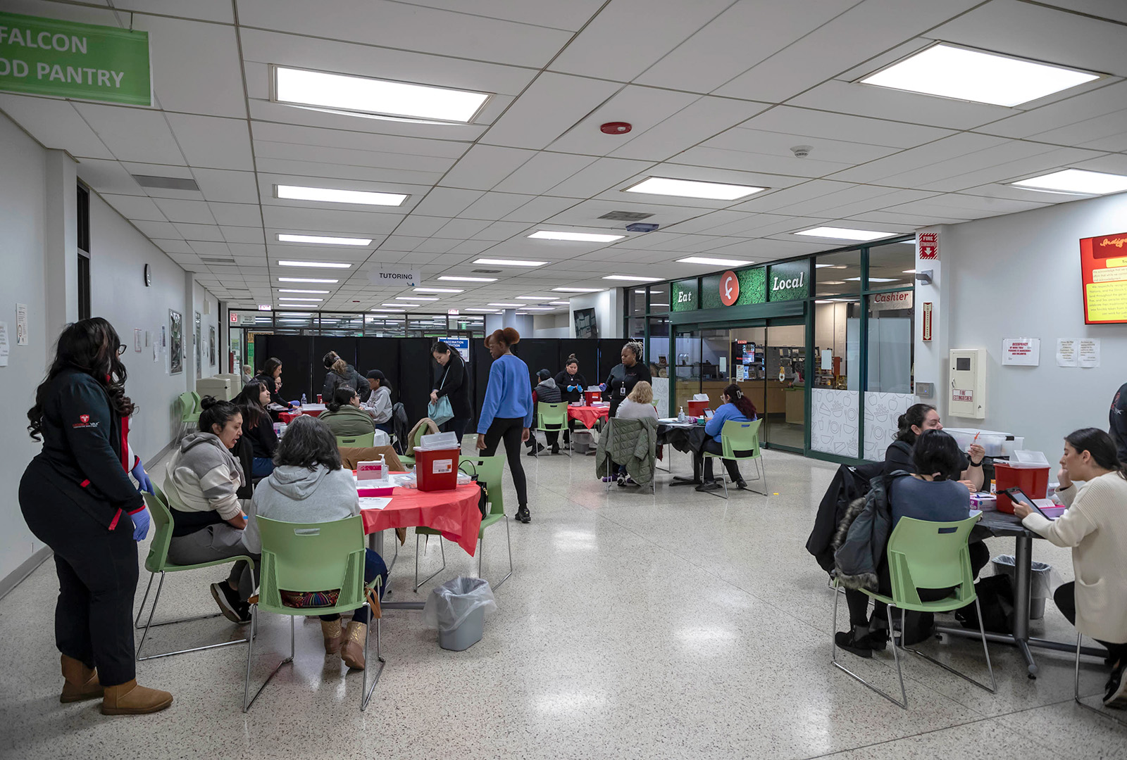 People sit at tables inside getting vaccination at a clinic in Chicago.