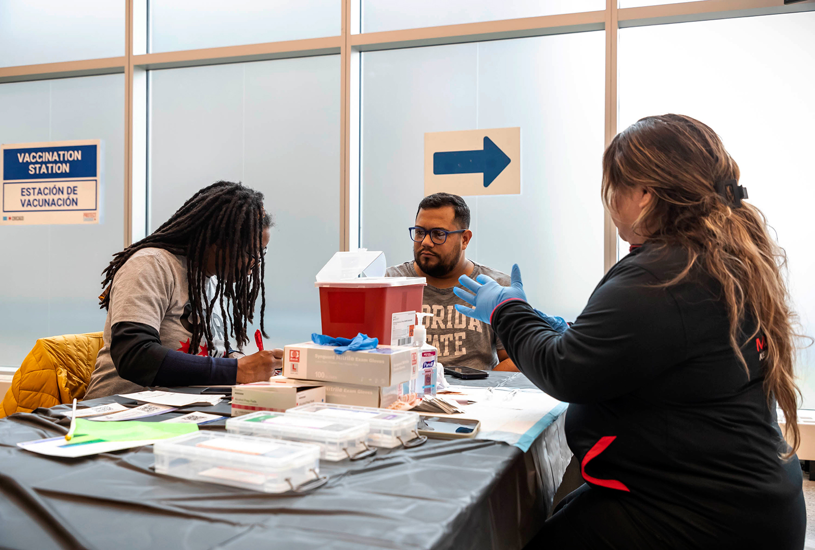 A man sitting at a table waiting to get his vaccine.