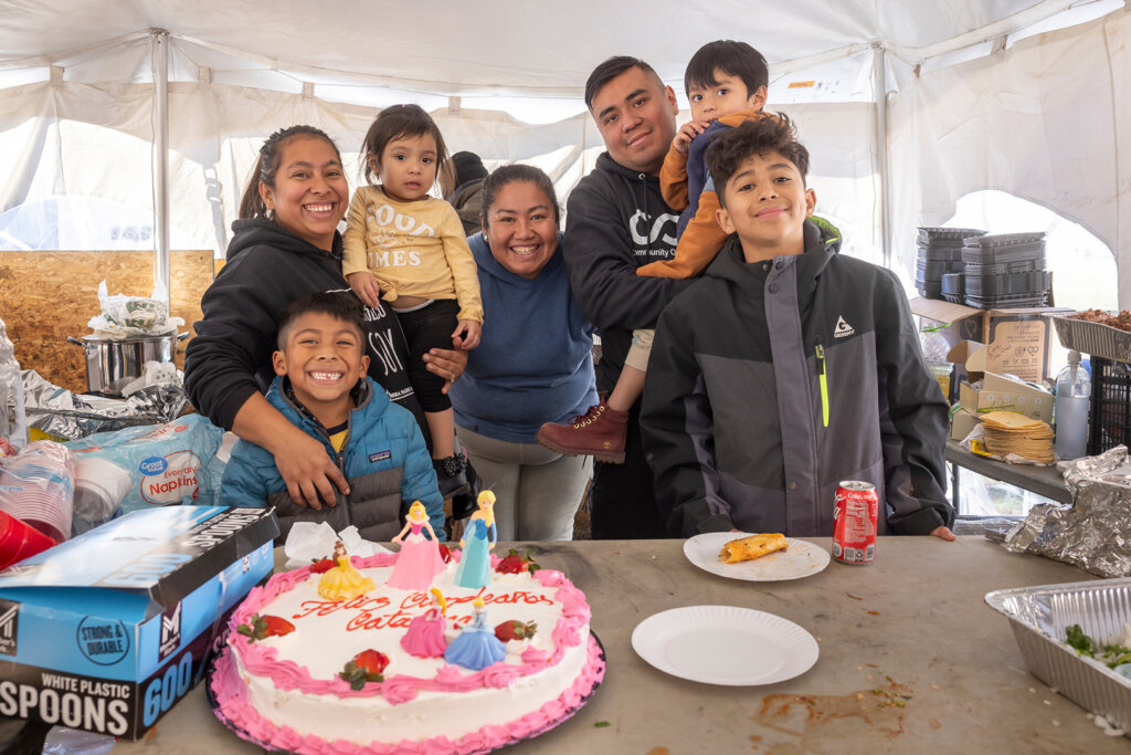 A family in NC smiles as they prepare food