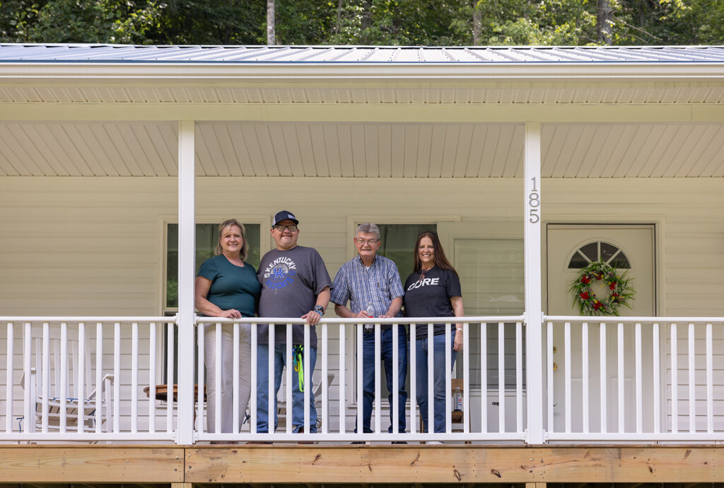 Bill, his son, Malva and Kim standing on the porch of Bill's new home