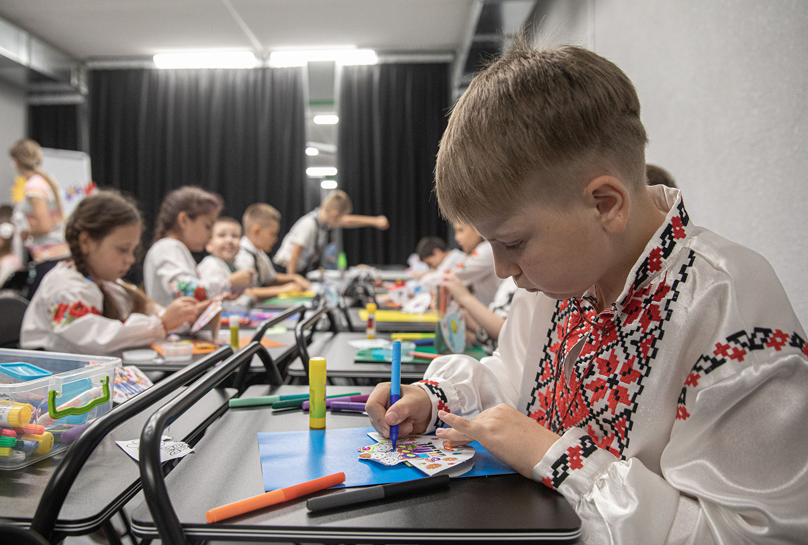 School children work on crafts during the opening of the Lyceum No. 55 shelter in Mykolaiv. CORE renovated the shelter with local partners to allow for classes to safely continue through air raid warnings in the only city 50 kilometers from the front lines.