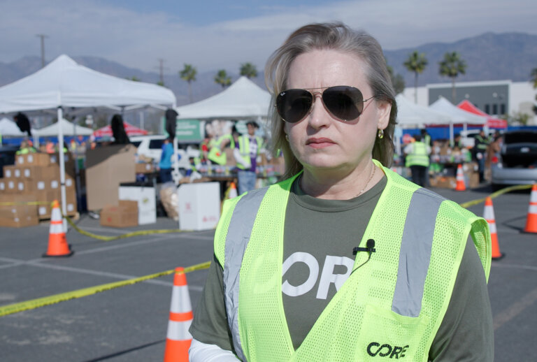 A CORE volunteer for their response to the fires, poses for a photo at a distribution event.