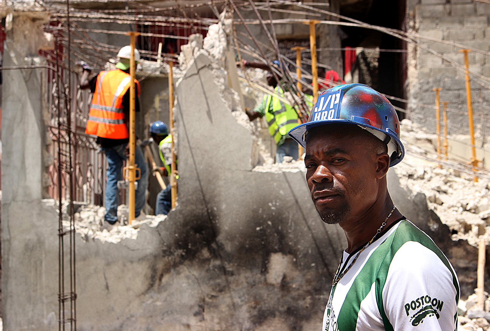 Workers demolish a damaged building by hand in June 2013. Many neighborhoods in Port-au-Price have narrow, tight corridors, limiting access to heavy machinery. In these areas crews demolished earthquake-damaged homes with hand tools, one floor at a time, from top to bottom. J/P HRO maintained a robust engineering department that repaired and retrofitted homes where possible and demolished them when not.