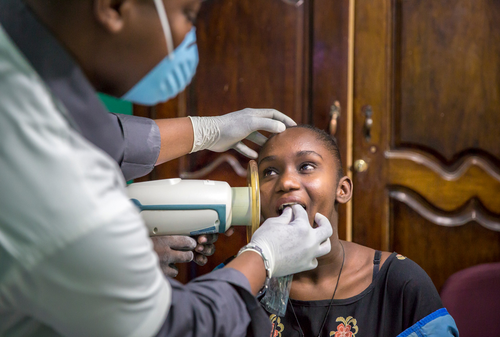 Dentists at the J/P HRO Dental Clinic use a handheld device to take an X-ray of a patient’s teeth in August 2015. In its earliest iterations in the Petionville Club Camp, the clinic   provided extraction services with the tools on hand. By 2014, the clinic had modernized and could provide restorative and preventative services in the Delmas 32 community.