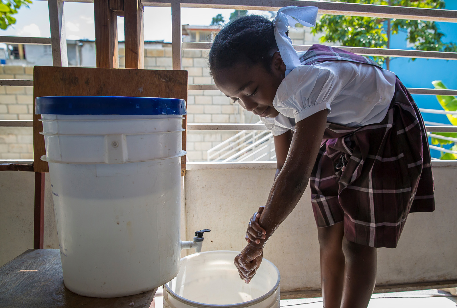 A student at a school in Delmas 32 cleans her hands at a washing station set up as part of a March 2018 Water Sanitation and Hygiene (WASH) initiative. WASH has been a cornerstone of our work in Haiti, reaching more than 55,000 individuals overall through addressing cholera epidemics, fostering school and community WASH programs, constructing toilet facilities, and rebuilding water systems in rural Haiti damaged in rural Haiti.